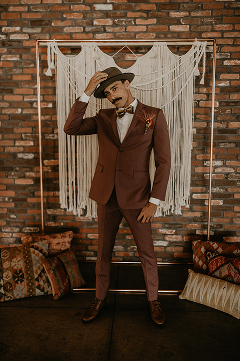  wedding at the colony house with bohemian touches and the groom in a rose pink suit and wide brimmed hat 