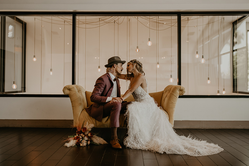  wedding at the colony house with bohemian touches and the groom in a rose pink suit and wide brimmed hat 