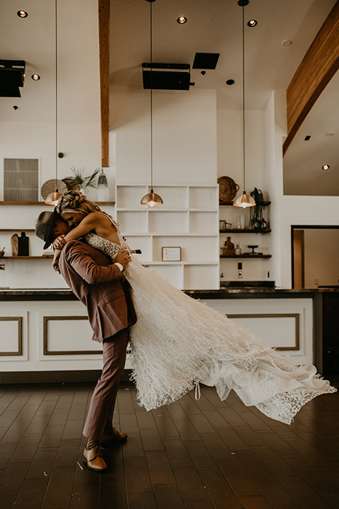  wedding at the colony house with bohemian touches and the groom in a rose pink suit and wide brimmed hat 