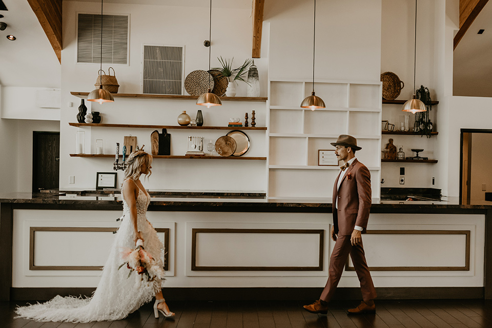  wedding at the colony house with bohemian touches and the groom in a rose pink suit and wide brimmed hat 