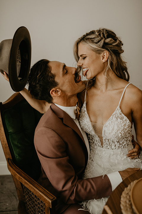  wedding at the colony house with bohemian touches and the groom in a rose pink suit and wide brimmed hat 