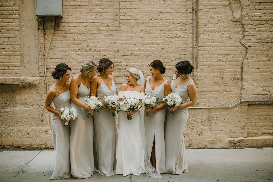  bride in an off the shoulder modern gown and the groom in a charcoal shawl lapel tuxedo 