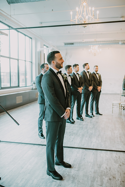  bride in an off the shoulder modern gown and the groom in a charcoal shawl lapel tuxedo 