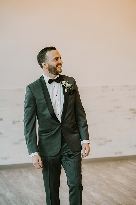  bride in an off the shoulder modern gown and the groom in a charcoal shawl lapel tuxedo 