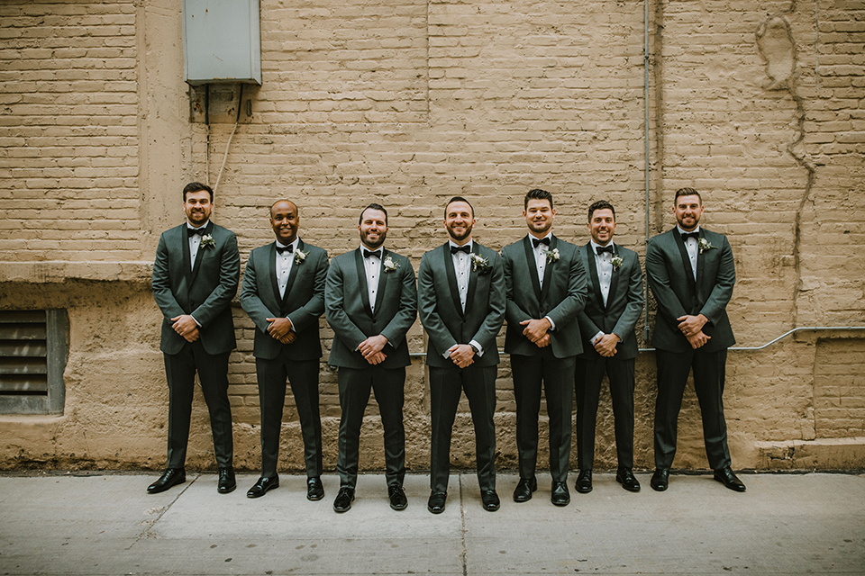  bride in an off the shoulder modern gown and the groom in a charcoal shawl lapel tuxedo 