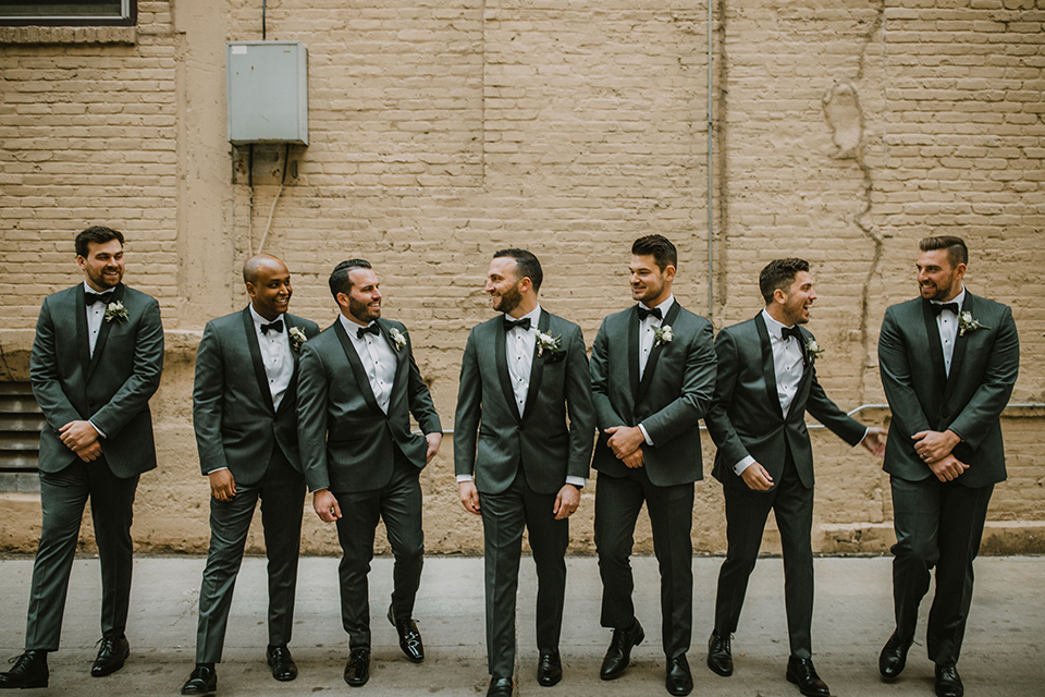  bride in an off the shoulder modern gown and the groom in a charcoal shawl lapel tuxedo 