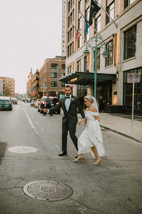  bride in an off the shoulder modern gown and the groom in a charcoal shawl lapel tuxedo 