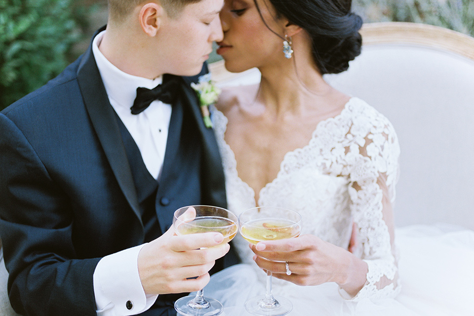  a gold and navy wedding at kestrel park with the groom in a navy tuxedo and the bride in a lace ballgown with long sleeves 