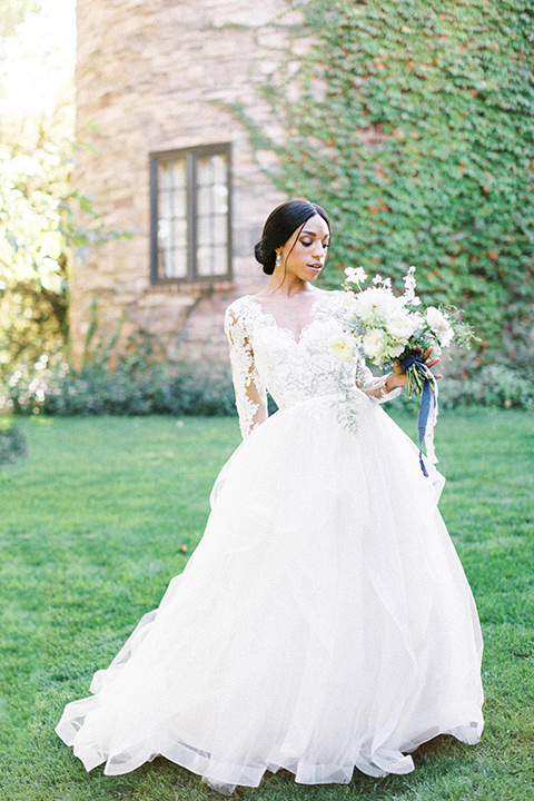  a gold and navy wedding at kestrel park with the groom in a navy tuxedo and the bride in a lace ballgown with long sleeves 