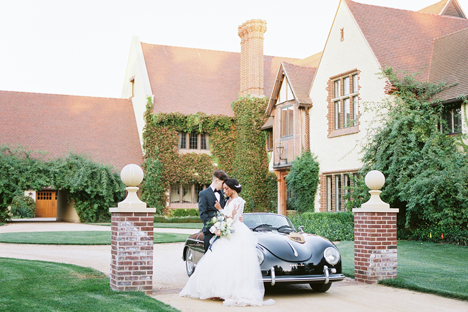  a gold and navy wedding at kestrel park with the groom in a navy tuxedo and the bride in a lace ballgown with long sleeves 