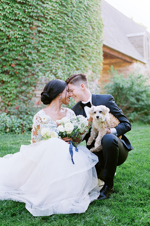  a gold and navy wedding at kestrel park with the groom in a navy tuxedo and the bride in a lace ballgown with long sleeves 