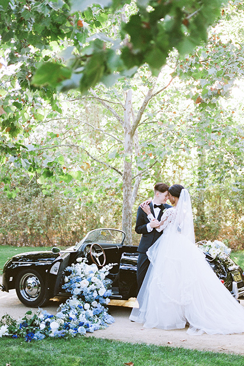  a gold and navy wedding at kestrel park with the groom in a navy tuxedo and the bride in a lace ballgown with long sleeves 