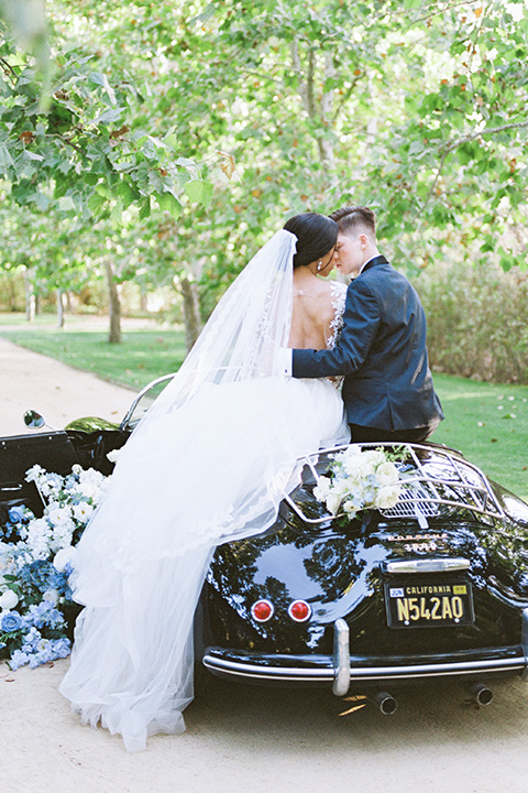  a gold and navy wedding at kestrel park with the groom in a navy tuxedo and the bride in a lace ballgown with long sleeves 