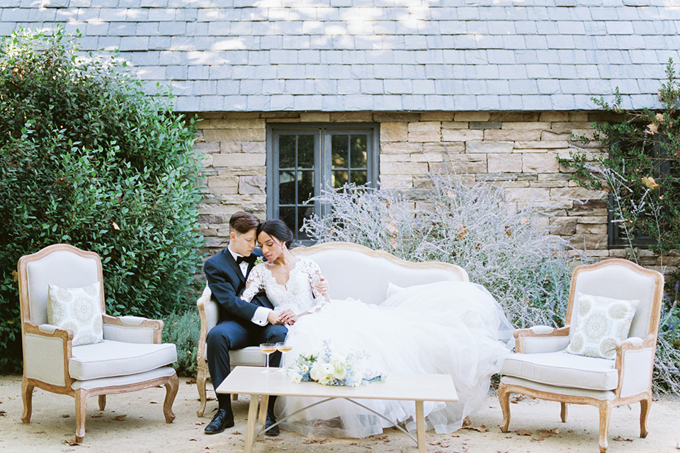  a gold and navy wedding at kestrel park with the groom in a navy tuxedo and the bride in a lace ballgown with long sleeves 