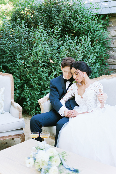  a gold and navy wedding at kestrel park with the groom in a navy tuxedo and the bride in a lace ballgown with long sleeves 