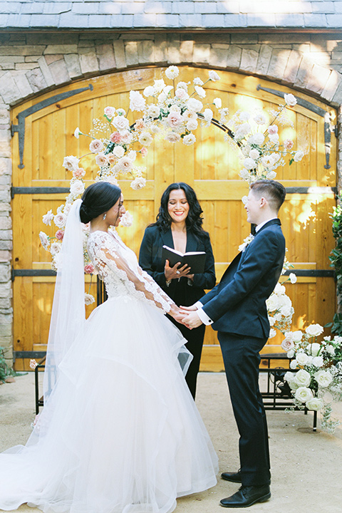  a gold and navy wedding at kestrel park with the groom in a navy tuxedo and the bride in a lace ballgown with long sleeves 