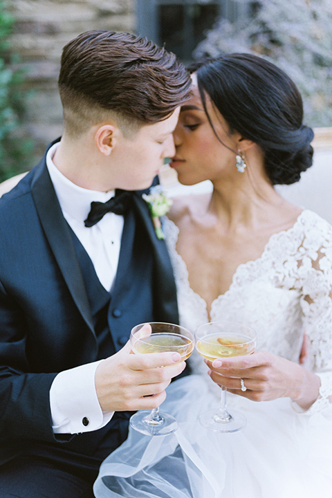  a gold and navy wedding at kestrel park with the groom in a navy tuxedo and the bride in a lace ballgown with long sleeves 