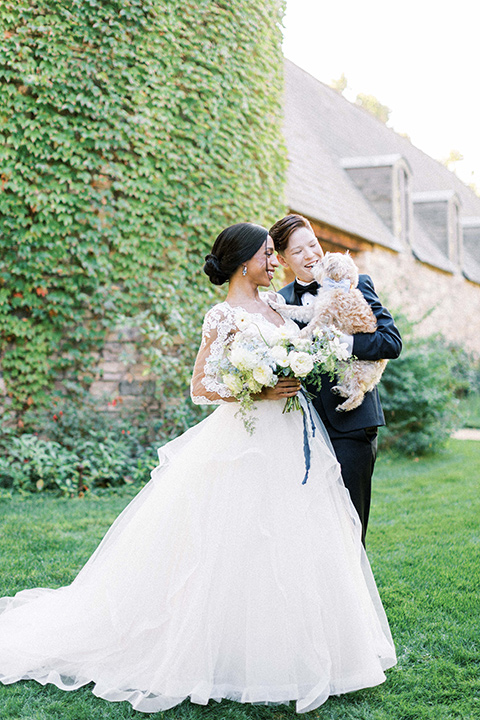  a gold and navy wedding at kestrel park with the groom in a navy tuxedo and the bride in a lace ballgown with long sleeves 