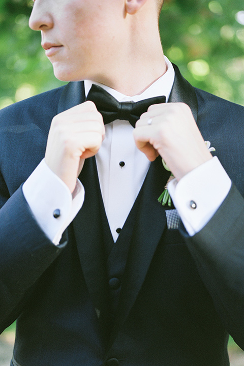  a gold and navy wedding at kestrel park with the groom in a navy tuxedo and the bride in a lace ballgown with long sleeves 