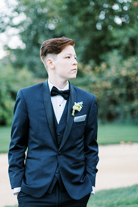  a gold and navy wedding at kestrel park with the groom in a navy tuxedo and the bride in a lace ballgown with long sleeves 