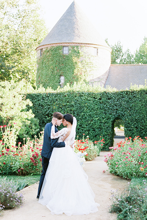  a gold and navy wedding at kestrel park with the groom in a navy tuxedo and the bride in a lace ballgown with long sleeves 