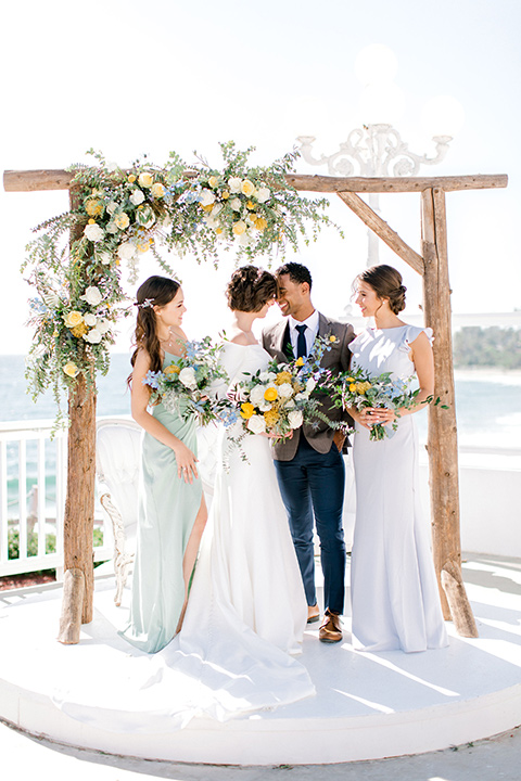  beach style wedding with the groom in a café brown coat and navy pant 