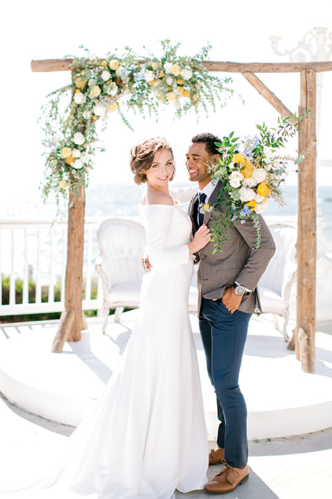  beach style wedding with the groom in a café brown coat and navy pant 