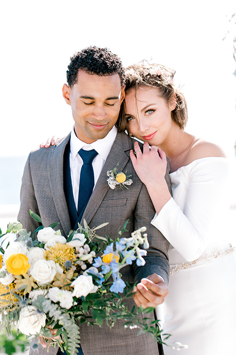  beach style wedding with the groom in a café brown coat and navy pant 