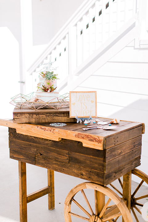  beach style wedding with the groom in a café brown coat and navy pant 