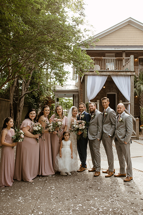  a romantic church wedding with the groom and groomsmen in cobalt blue suit and the bridesmaids in blush and the bride in a lace fitted gown 