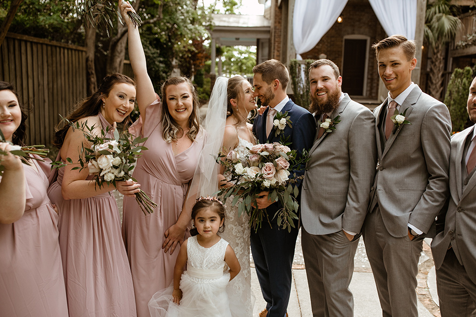  a romantic church wedding with the groom and groomsmen in cobalt blue suit and the bridesmaids in blush and the bride in a lace fitted gown 