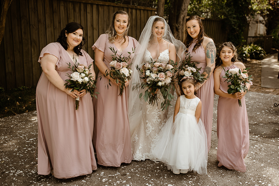  a romantic church wedding with the groom and groomsmen in cobalt blue suit and the bridesmaids in blush and the bride in a lace fitted gown 