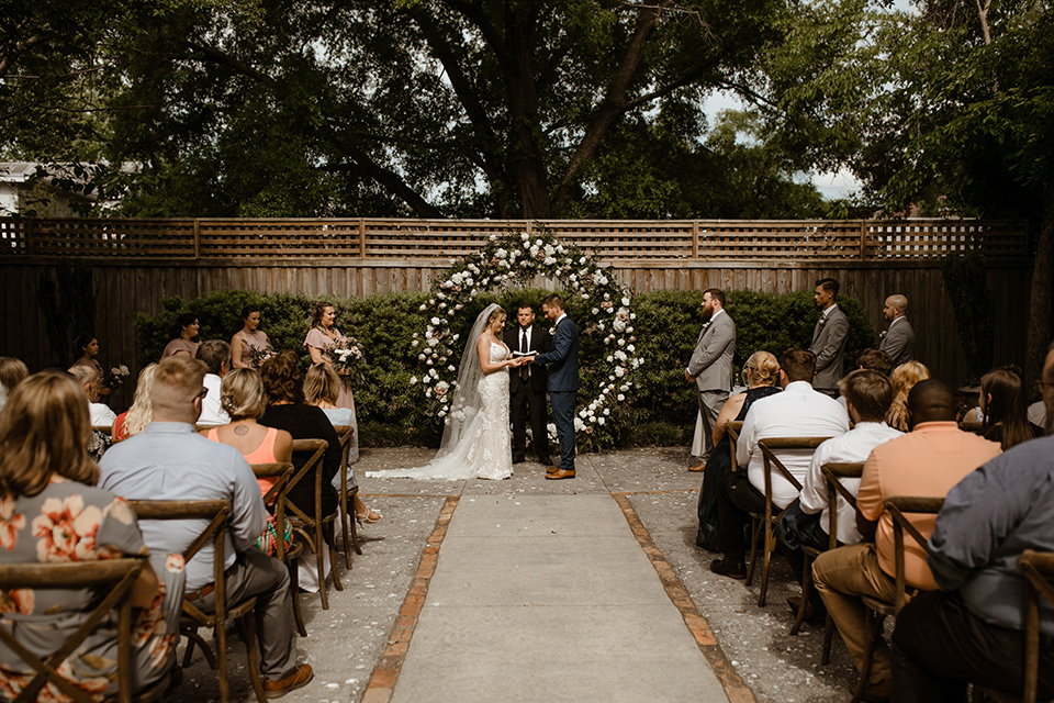  a romantic church wedding with the groom and groomsmen in cobalt blue suit and the bridesmaids in blush and the bride in a lace fitted gown 