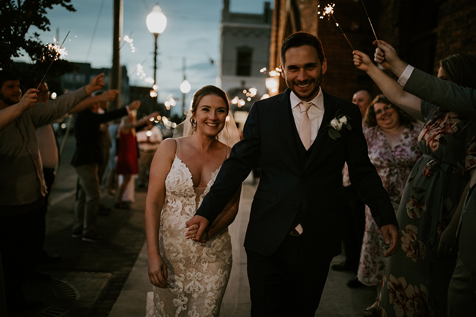  a romantic church wedding with the groom and groomsmen in cobalt blue suit and the bridesmaids in blush and the bride in a lace fitted gown 