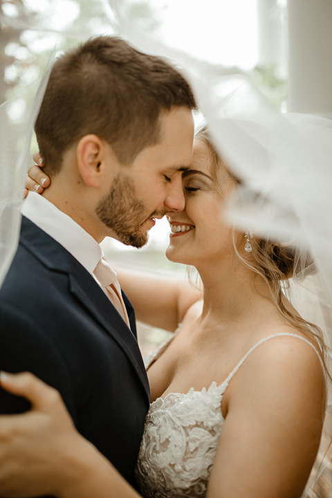  a romantic church wedding with the groom and groomsmen in cobalt blue suit and the bridesmaids in blush and the bride in a lace fitted gown 