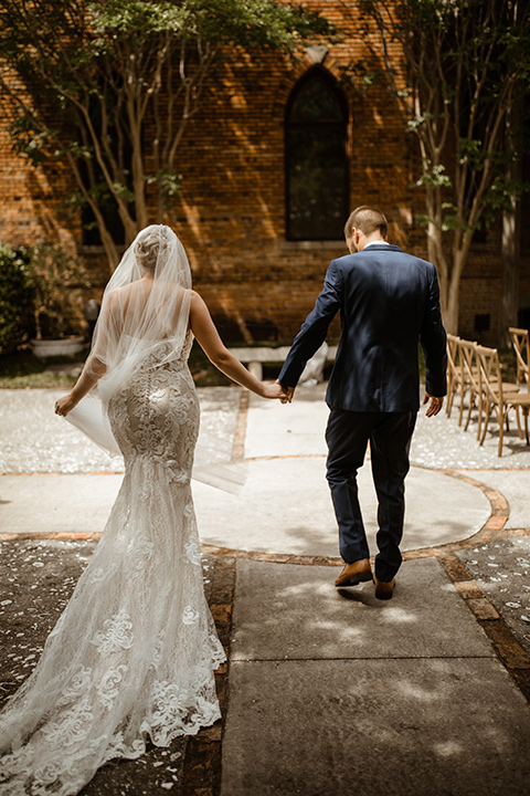  a romantic church wedding with the groom and groomsmen in cobalt blue suit and the bridesmaids in blush and the bride in a lace fitted gown 