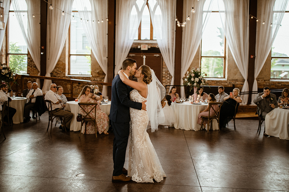  a romantic church wedding with the groom and groomsmen in cobalt blue suit and the bridesmaids in blush and the bride in a lace fitted gown 