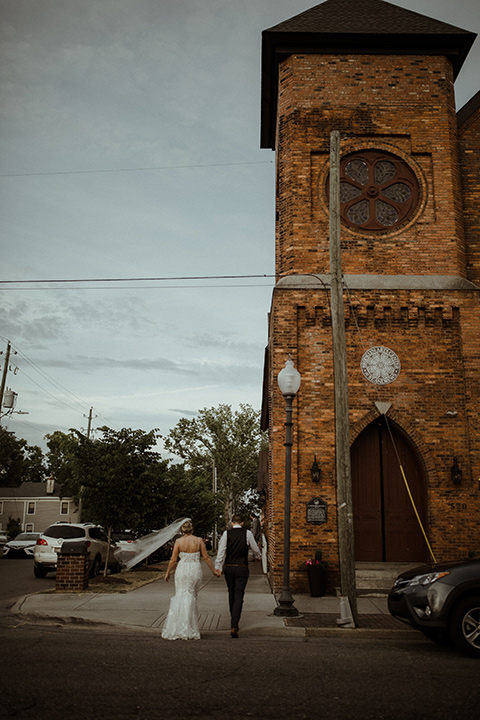  a romantic church wedding with the groom and groomsmen in cobalt blue suit and the bridesmaids in blush and the bride in a lace fitted gown 