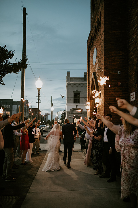  a romantic church wedding with the groom and groomsmen in cobalt blue suit and the bridesmaids in blush and the bride in a lace fitted gown 