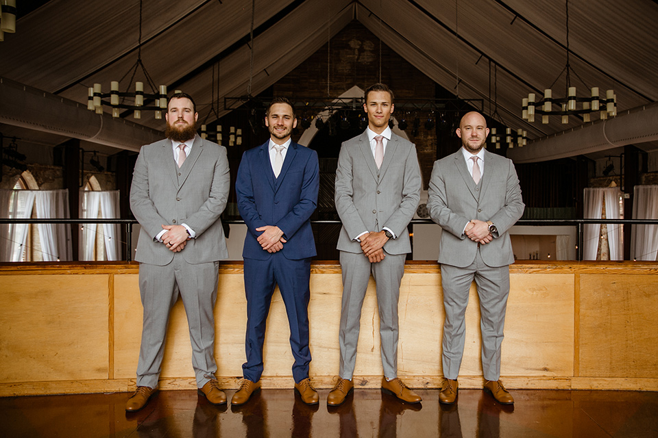  a romantic church wedding with the groom and groomsmen in cobalt blue suit and the bridesmaids in blush and the bride in a lace fitted gown 