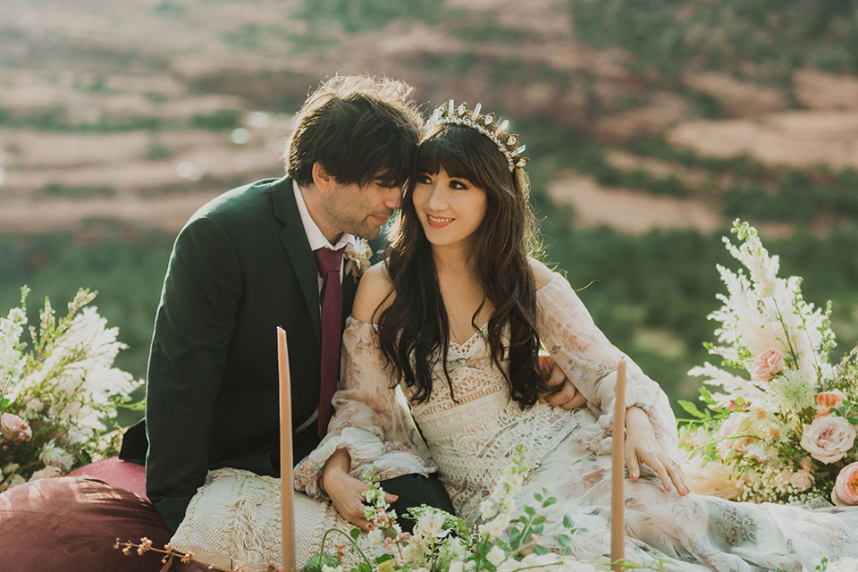  Sedona elopement with bohemian flare – the groom in a green suit and the bride in a boho dress and jean jacket 
