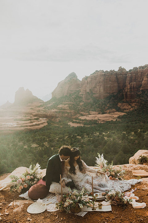  Sedona elopement with bohemian flare – the groom in a green suit and the bride in a boho dress and jean jacket 