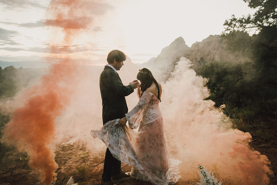  Sedona elopement with bohemian flare – the groom in a green suit and the bride in a boho dress and jean jacket 