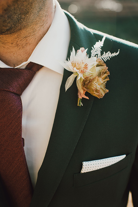  Sedona elopement with bohemian flare – the groom in a green suit and the bride in a boho dress and jean jacket 