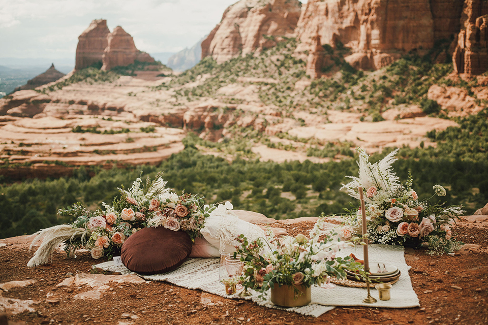  Sedona elopement with bohemian flare – the groom in a green suit and the bride in a boho dress and jean jacket 