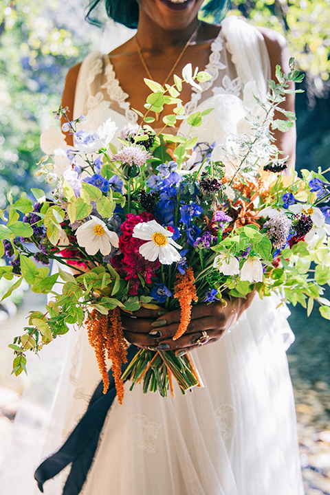  boho wedding with the ceremony inside and the reception on the cliffs overlooking the ocean and the bride in a finged gown and the groom in a tan suit 