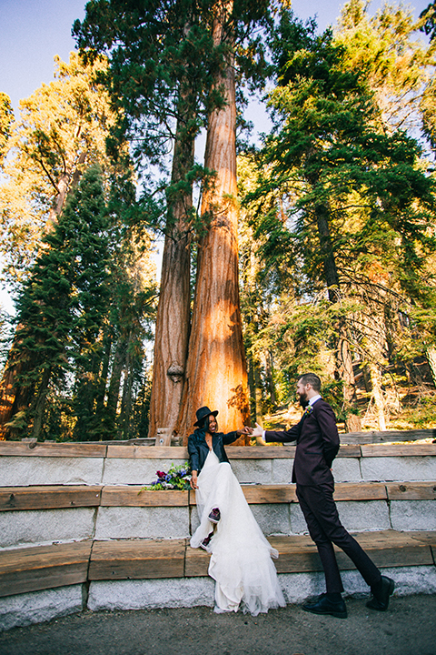  boho wedding with the ceremony inside and the reception on the cliffs overlooking the ocean and the bride in a finged gown and the groom in a tan suit 