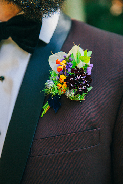  boho wedding with the ceremony inside and the reception on the cliffs overlooking the ocean and the bride in a finged gown and the groom in a tan suit 