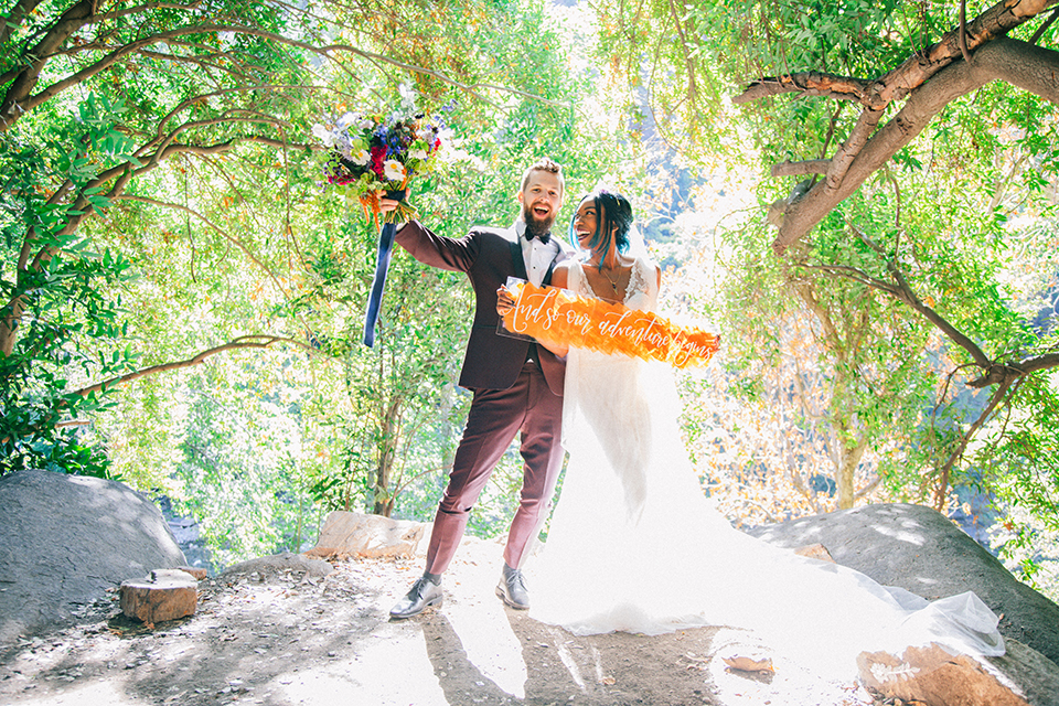  boho wedding with the ceremony inside and the reception on the cliffs overlooking the ocean and the bride in a finged gown and the groom in a tan suit 