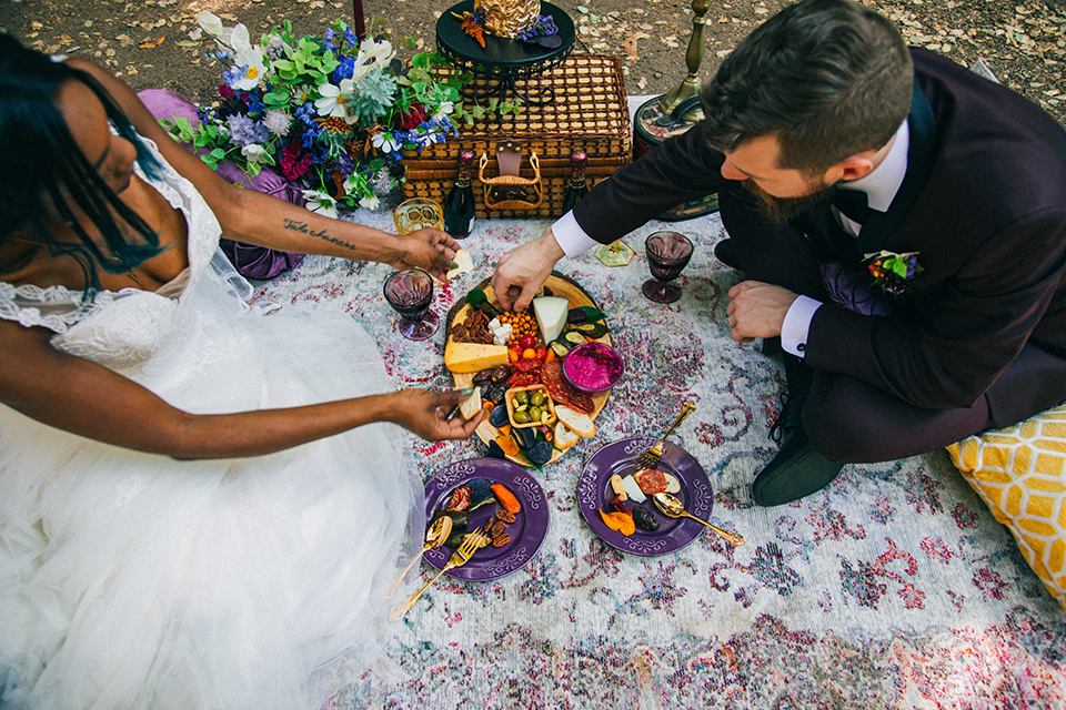  boho wedding with the ceremony inside and the reception on the cliffs overlooking the ocean and the bride in a finged gown and the groom in a tan suit 